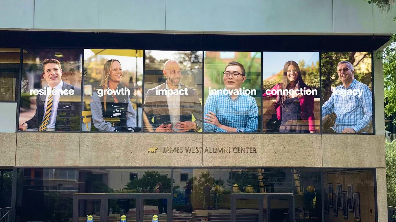 Story-led window graphics on the alumni centre.